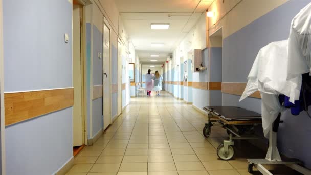 Duas enfermeiras com roupões especiais estão no corredor do hospital — Vídeo de Stock