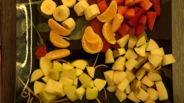 Teller mit Früchten einer Mandarine und einer Erdbeerbanane — Stockvideo