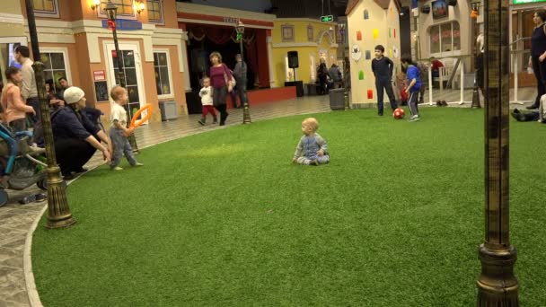 Děti a děti hrají na zelené umělé trávě v dětský svět — Stock video
