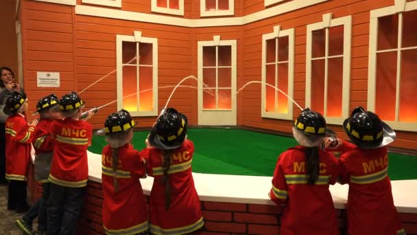 Kinder in Helmen und Sonderform löschen den Brand eines Wohnhauses aus Feuerwehrschläuchen — Stockvideo