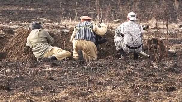 Soldados con rifles de asalto y una bazuca se sientan en una trinchera en las hostilidades — Vídeo de stock