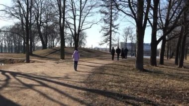 insanlar üzerinde soğuk bir sonbahar Meydanı çıplak ağaçlar arasında yürümek.
