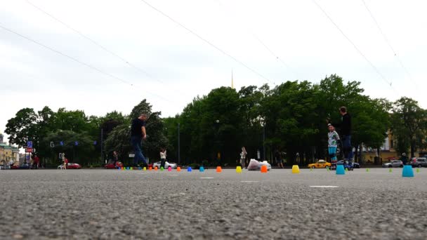 Спортсмены на роликовых коньках и в форме ездят по тротуару с препятствиями — стоковое видео