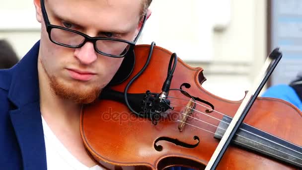 Violinisten pressar fiol till hakan och plocka strängarna med en båge — Stockvideo