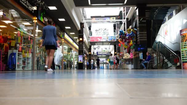 As pessoas caminham no complexo comercial e de entretenimento — Vídeo de Stock
