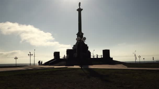 El contorno del monumento urbano con los brazos de Rusia en forma de pilar y los visitantes — Vídeos de Stock