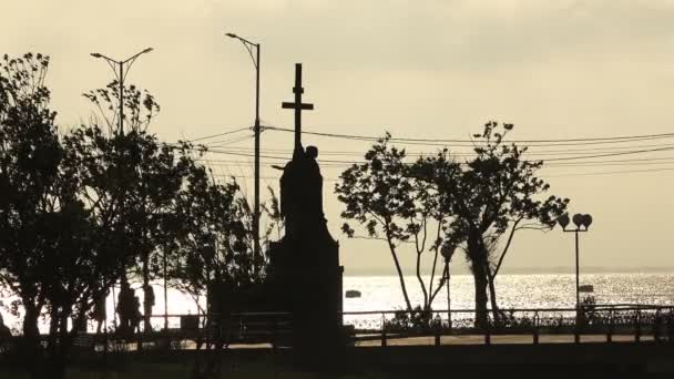 Et monument på sjøsiden med kors nær kysten av havet – stockvideo