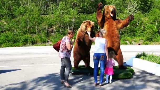 Turistas están considerando la escultura artificial de dos oso pardo de pie en sus patas traseras — Vídeos de Stock