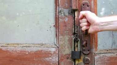 Bir insan eli bir kırmızı kahverengi çürük kapı kapı kolu alır