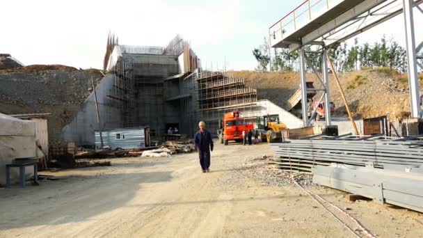 Maître en robes et casques promenades le long du chantier près de l'entrepôt métallurgique — Video