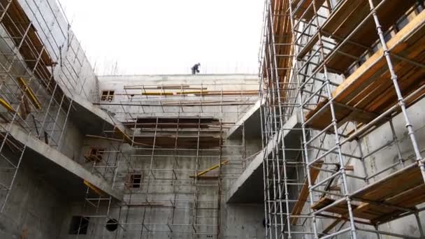 Arbetstagare i en särskild uniform arbetar på höjden av byggnaden — Stockvideo