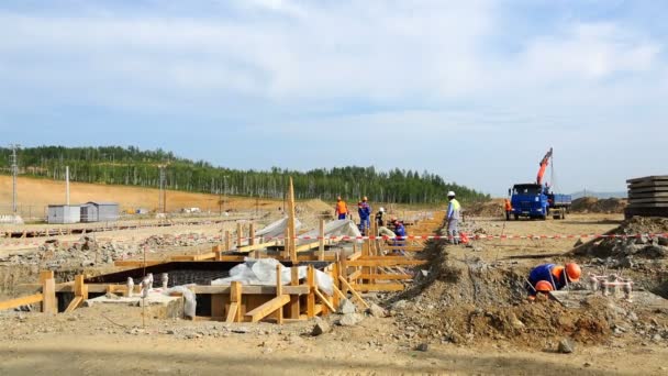Constructores realizan trabajos de cimentación bajo tierra bajo el ciclo inicial de trabajo — Vídeos de Stock