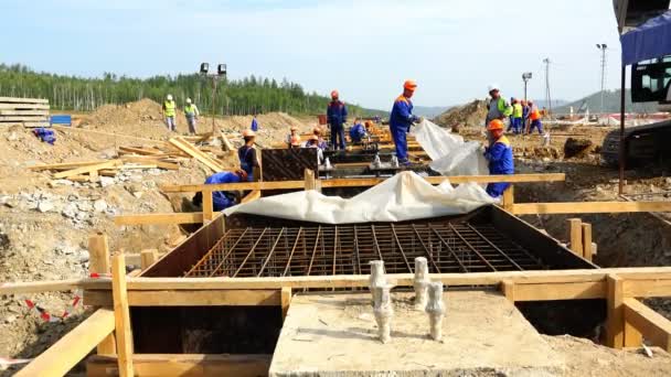 Un team di operai del cantiere isolano la fondazione con un film di precipitazioni — Video Stock