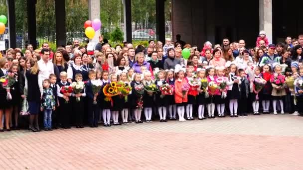 Schoolmeisjes van primaire klassen staan op de lijn op de dag van de kennis — Stockvideo