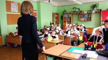 Sınıfındaki çocuklar öğretmenin sorulara cevap onların ellerini çek