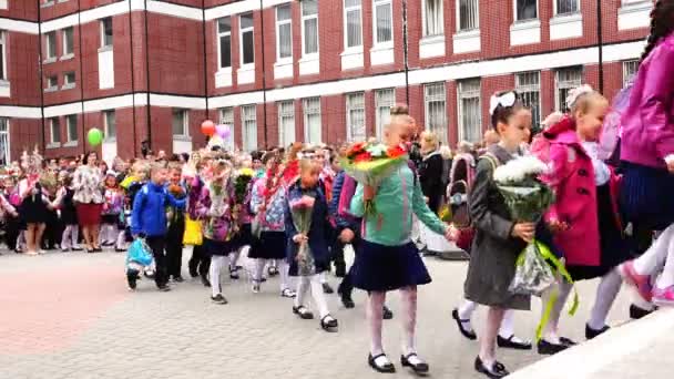 Дети празднуют День знаний с цветами и воздушными шарами — стоковое видео