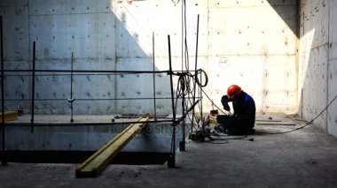 yüklemeyi gerçekleştiren demir ile çalışan bir bornoz ve kask bir beton zemin