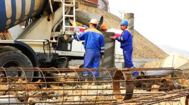 İşçi şantiyede beton Beton mikseri almak ve bir kasa içine bir kasa içine dökülür