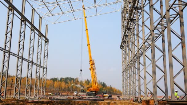 Jeřáb se přesune zatížení na staveništi zvednutím s praky a háčkem — Stock video