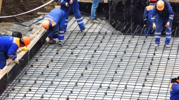 Hombres en una herramienta de bata refuerzo de punto para una losa de cimentación — Vídeo de stock