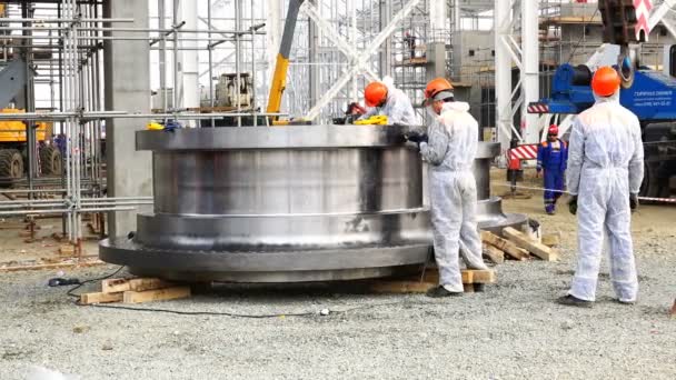 Arbeiter in Spezialkleidung schleift Metallwerkzeug — Stockvideo