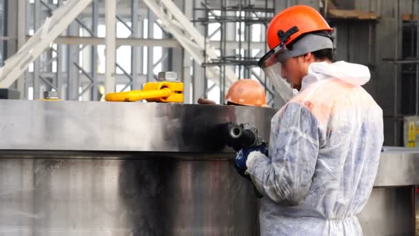 Квалифицированный рабочий обрабатывает металлическую деталь шлифовальным станком — стоковое видео