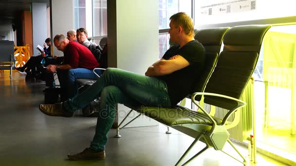 A man in jeans and a T-shirt gets up from an armchair leaving for a frame — Stock Video