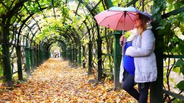 sonbahar yağmurlu havalarda bir cadde üzerinde bir şemsiye altında bir kız bebek rahim içinde duruyor