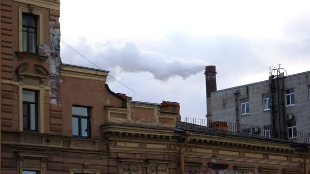 Una pipa de producción fuma sobre techos de casas de la ciudad — Vídeos de Stock