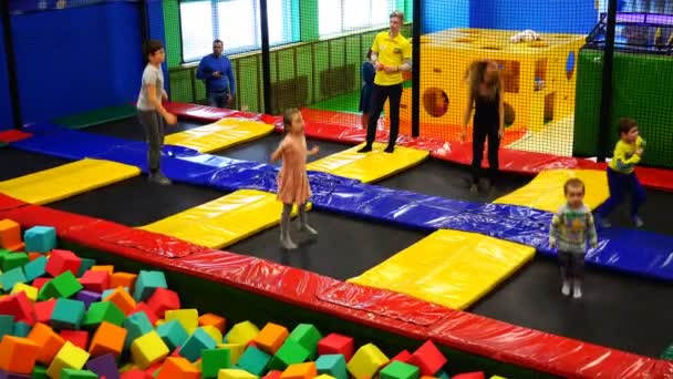 Saltando em um trampolim e escalada em um parque de recreação ativo — Vídeo de Stock