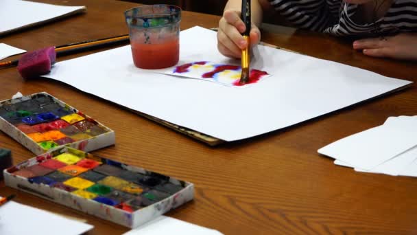 Agua, acuarela y colores brillantes de colores crean un patrón en una tira de papel — Vídeo de stock