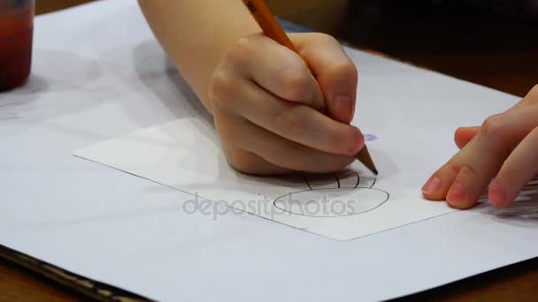 그의 오른손을 가진 아이 종이 조각에 간단한 연필 태양을 그립니다. — 비디오
