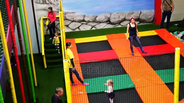 Niños y adultos saltando en el trampolín en la sala de juegos — Vídeos de Stock