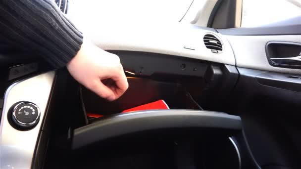 The hand takes out a red rag from the bottom of the car glove compartment — Stock Video