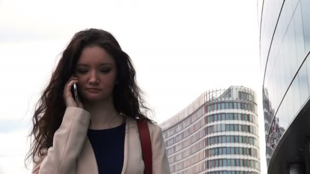 Деловая женщина в куртке ведет деловые переговоры по телефону — стоковое видео