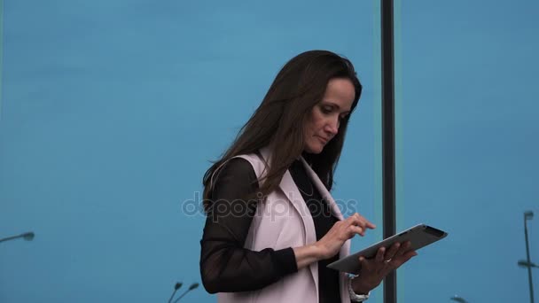 Een vrouw in een zakelijke stijl beheert bedrijfsprocessen op een Tablet PC — Stockvideo