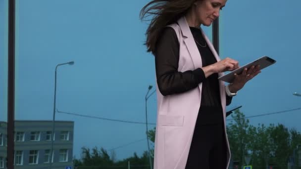 Ein Mädchen löst kommerzielle und finanzielle Probleme mit einem Tablet — Stockvideo