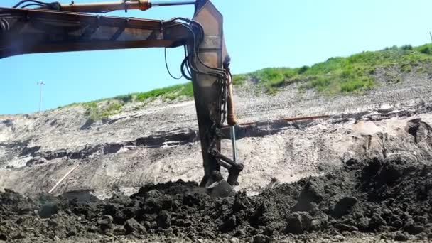 Ведро экскаватора загружает глину и перегружает ее в другое место — стоковое видео