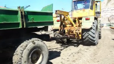 Bir römork ile dolu bir buldozer malzeme dağlık koşullarda taşır..