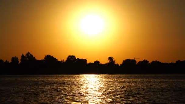 Ярко-желтое солнце над рекой — стоковое видео