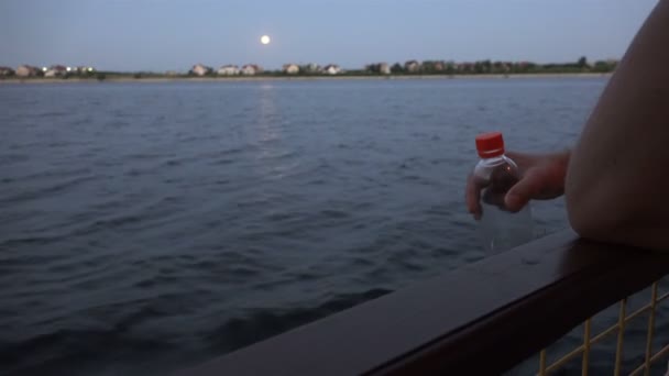 Un marinero sosteniendo una botella de plástico con una tapa roja en la cubierta — Vídeo de stock