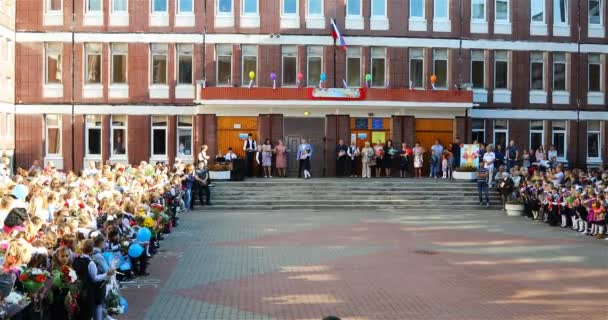 Een middelbare scholier met een eerstejaars deed de eerste belletje rinkelen — Stockvideo