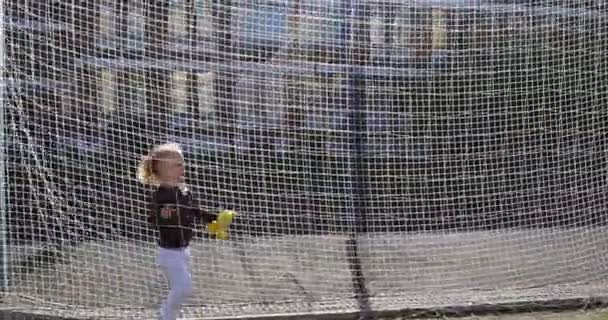 Een driejarig meisje struikelt over het net van een voetbaldoelpunt en valt op haar knieën — Stockvideo