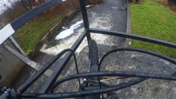 Переднее колесо велосипеда на бетонной плите замка речной системы — стоковое видео