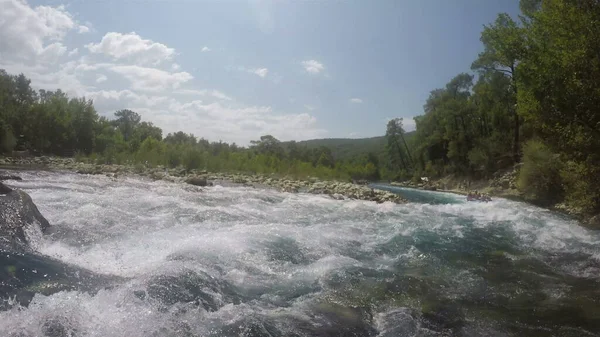 Fırtınalı bir nehirde şişme bir teknede rafting yapmak. Birinci şahıs vuruldu.