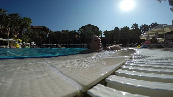 Kız kendini havuzdan gelen soğuk suyla duruluyor.