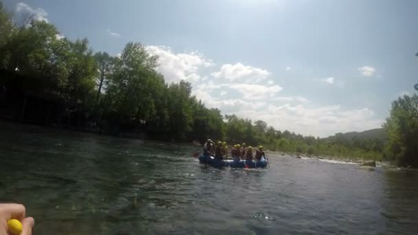 Un grupo de atletas en un barco de goma azul hace un viaje en balsa por el río — Vídeo de stock