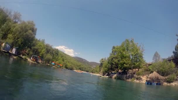 Grupos de personas en los barcos se dedican a rafting en un río de montaña — Vídeo de stock