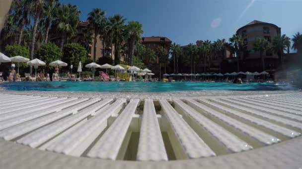 Niños saltan a la piscina al aire libre desde la acera — Vídeo de stock