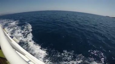 Bir deniz aracı hızla mavi denizi dalgalarla keser.